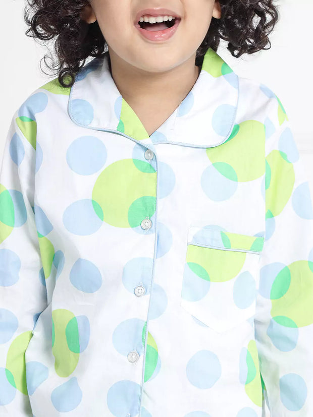 Child wearing a colorful polka dot shirt with a white background