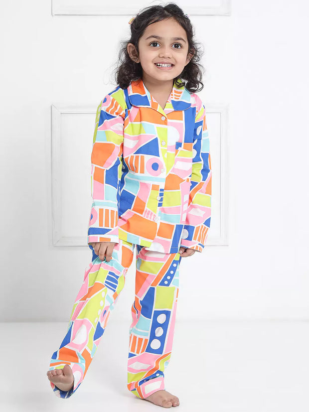 Child wearing a colorful geometric patterned pajama set on a white background
