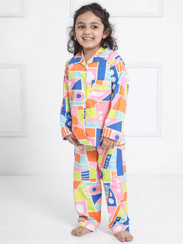 Child wearing a colorful geometric patterned onesie against a white background