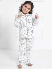 Child wearing a white pajama set with black patterns on a white background